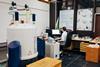 A scientist in a lab working on a computer and NMR machine