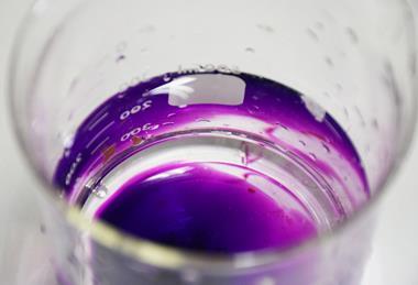 A photograph showing potassium permanganate in a glass beaker