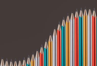 A photographic illustration of a series of pencils arranged side-by-side with points following the shape of an upward curve, as if on a graph