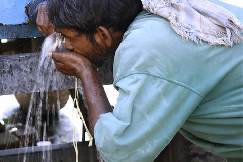 Man drinking water from tank